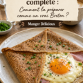 Une galette bretonne complète garnie de jambon, emmental et œuf sur une assiette, prête à être déguster.