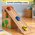 Enfant s'amusant à faire rouler des voitures sur une rampe en carton réalisée à la maison